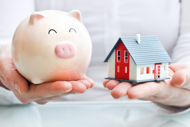 Signs It’s Time To Update Your Estate Plan - Hands holding a piggy bank and a house model