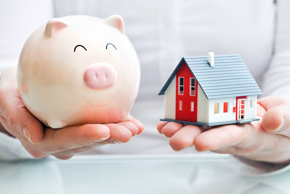 Signs It’s Time To Update Your Estate Plan - Hands holding a piggy bank and a house model