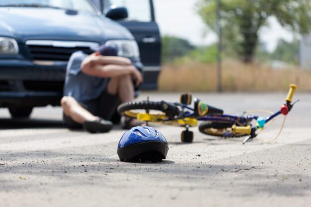 bike accident lawyer with helmet on ground